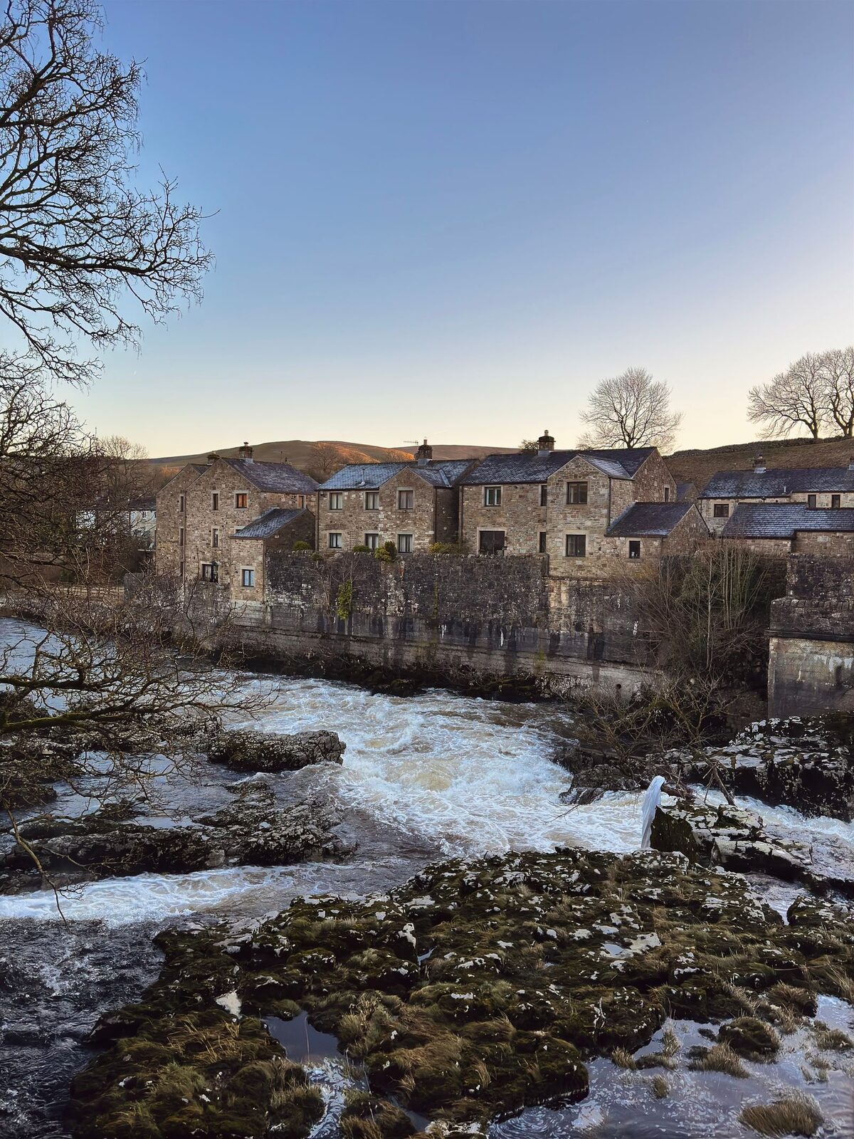 Stone houses beside a river in a dales village