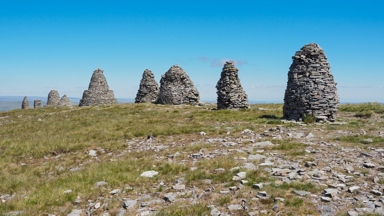 The stone cairns of Nine Standards Rigg on a clear day, with the Eden valley far below