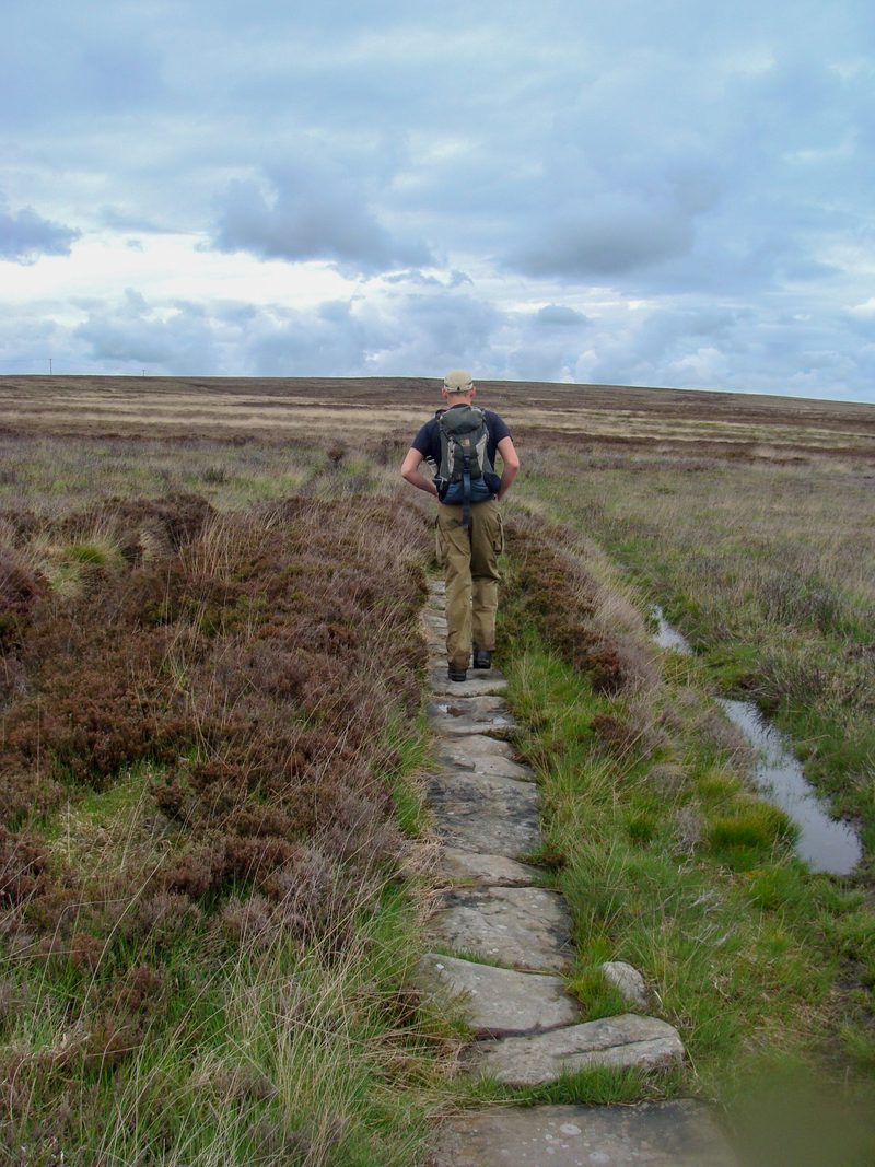 A walker on a flagstone path across the North York Moors